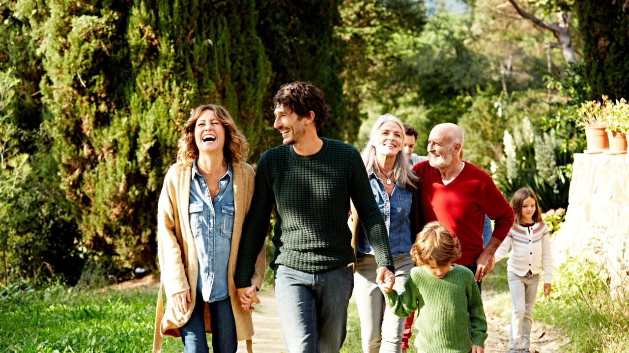 Seven people walking through nature, smiling and chatting
