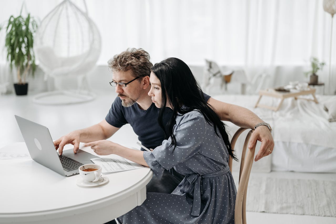A Couple Sitting while Looking at Laptop